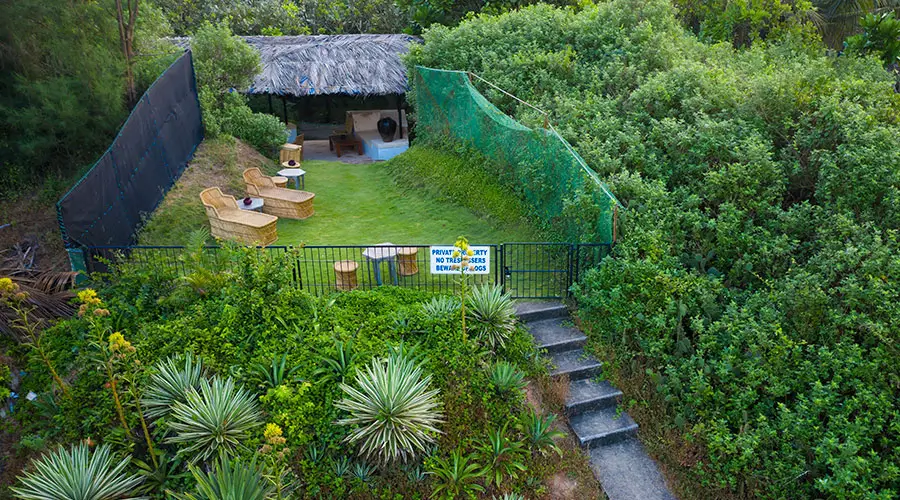 Private garden lawn with outdoor seating and a shaded hut offering a calm beachside space close to Candolim Beach North Goa!