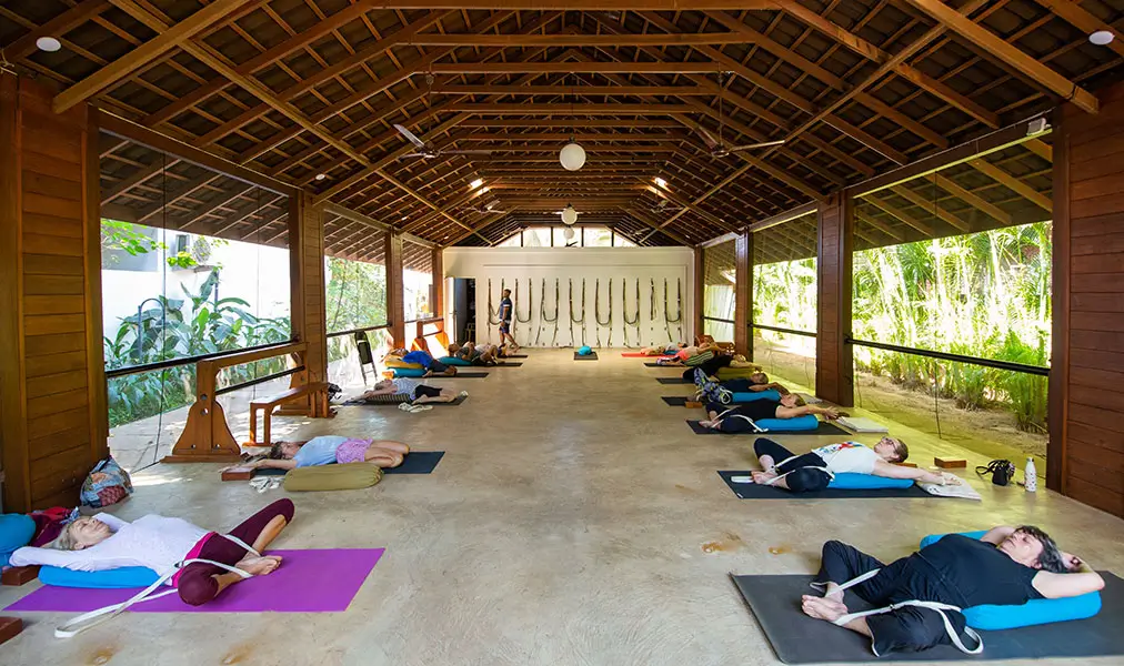 Restorative yoga class laid out on mats inside the spacious yoga pavilion at Aashyana Lakhanpal villas and cottages