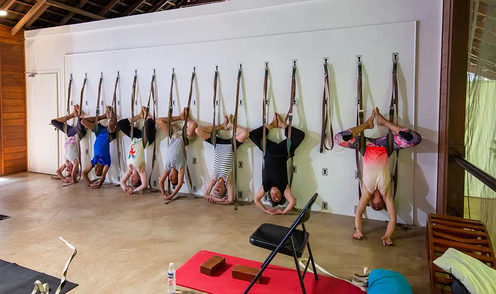 Guests practice supported yoga inversions inside the yoga pavilion at Aashyana Lakhanpal