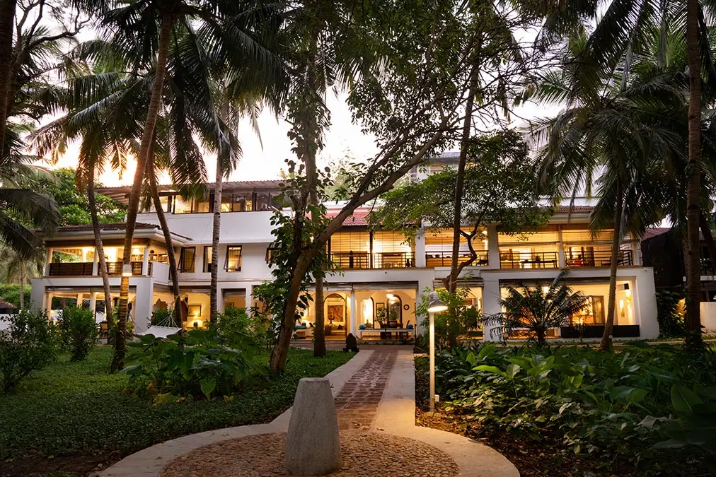 Villa Aashyana at Aashyana Lakhanpal, a private five-bedroom estate surrounded by lush gardens, softly lit pathways, and calm beachfront living.