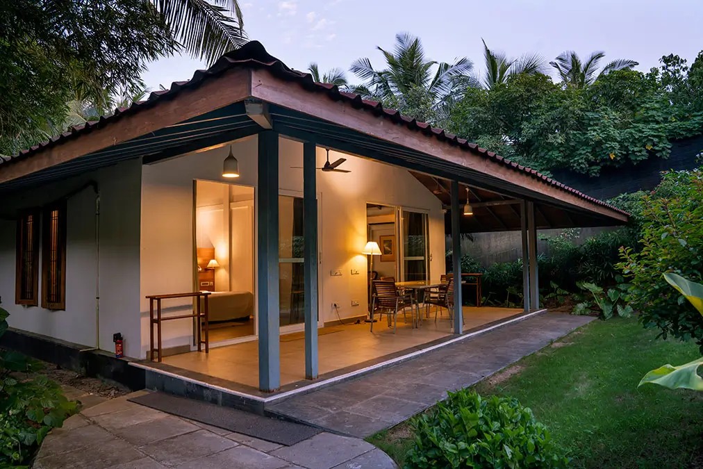 Virgo 2-bedroom cottage at Aashyana Lakhanpal, featuring a private veranda, garden seating, and a peaceful, nature-surrounded stay near the beach.